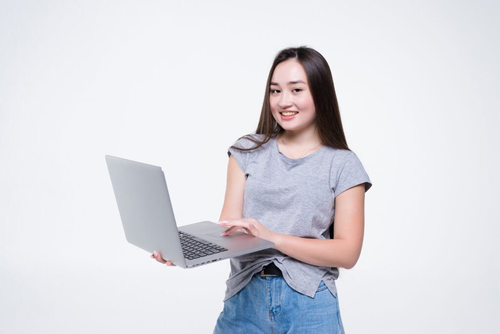 About Us 2 attractive smiling young woman holding laptop computer isolated white wall